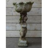 Stone effect shaped acanthus leaf moulded garden planter, held aloft by cherub on plinth, H102cm,
