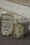 Two carved stone face ornaments