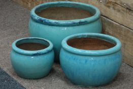 Three graduating blue glazed planters,