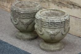 Pair classical style composite stone urns with Greek key detail,