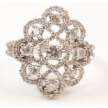 Diamond set ring in open work scroll setting comprising centre diamond,