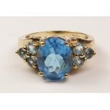 Gold ring set with large central apatite and further apatites to the shoulders hallmarked 9ct