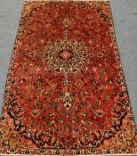 Persian Kashan red ground rug, overall floral design with large central rosette,