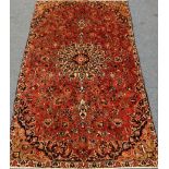 Persian Kashan red ground rug, overall floral design with large central rosette,
