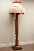 20th century mahogany standard lamp, heavily carved with foliage, on moulded stepped plinth,