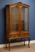 Reproduction walnut display cabinet, glazed with bevelled glass, shaped top with carved pediment,