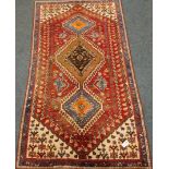 Persian Shiraz red ground rug, triple pole medallion, stylised motifs,
