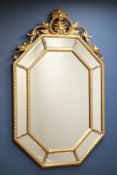 Octagonal wall mirror in gilt frame with sectional mirrored border and ornate pediment, W89cm,