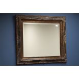 Ornate black lacquered and gilt bevelled edge wall mirror (82cm x 73cm),