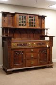 Arts and Crafts period oak sideboard, the base fitted with five drawers and two cupboards,