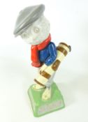 Dunlop Caddie figure carrying a golf bag with three clubs, inscribed “We play Dunlop" to the base,