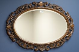 20th century carved oak framed oval mirror, bevelled glass,