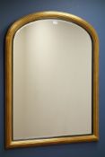 Gilt framed overmantel mirror with arched top and bevelled glass,