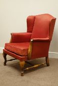 Walnut framed wingback armchair upholstered in red fabric,