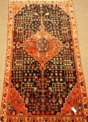 Persia Hamadan red ground rug, tree of life motifs with pole medallion on blue field.