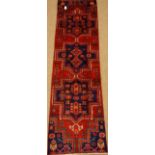 Persian Hamadan red ground rug with three blue medallions, geometric design,