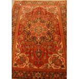 Persian Meshed red ground rug, large central rosette repeated within boarder, overall floral design,