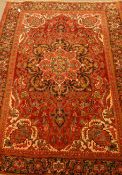 Persian Meshed red ground rug, large central rosette repeated within boarder, overall floral design,