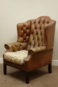 Georgian style wingback armchair upholstered in buttoned tan leather,
