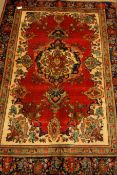 Persian Tabriz rug, cream ground with red field, within blue board, floral design,
