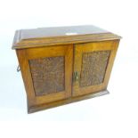 Edwardian oak smoker's cabinet with carved panels and later contents including a brass tobacco jar