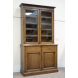 Edwardian oak bookcase on cupboard, raised bookcase enclosed by two glazed doors, four shelves,
