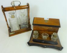 Late 19th/ early 20th Century walnut lacquered desk stand and a Edwardian oak two bottle Tantalus