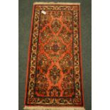 Small Persian pink ground rug with floral decoration,