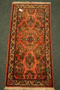 Small Persian pink ground rug with floral decoration,