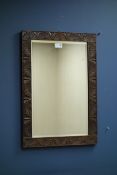 Oak framed rectangular wall mirror with bevelled plate and carved detail.