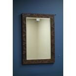 Oak framed rectangular wall mirror with bevelled plate and carved detail.