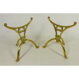 Pair of early 20th Century brass fire dogs on swept tripod feet, H18.