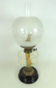 Victorian brass oil lamp with clear glass reservoir and opaque shade,
