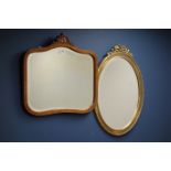 Reproduction walnut framed mirror with carved pediment and an oval gilt framed mirror