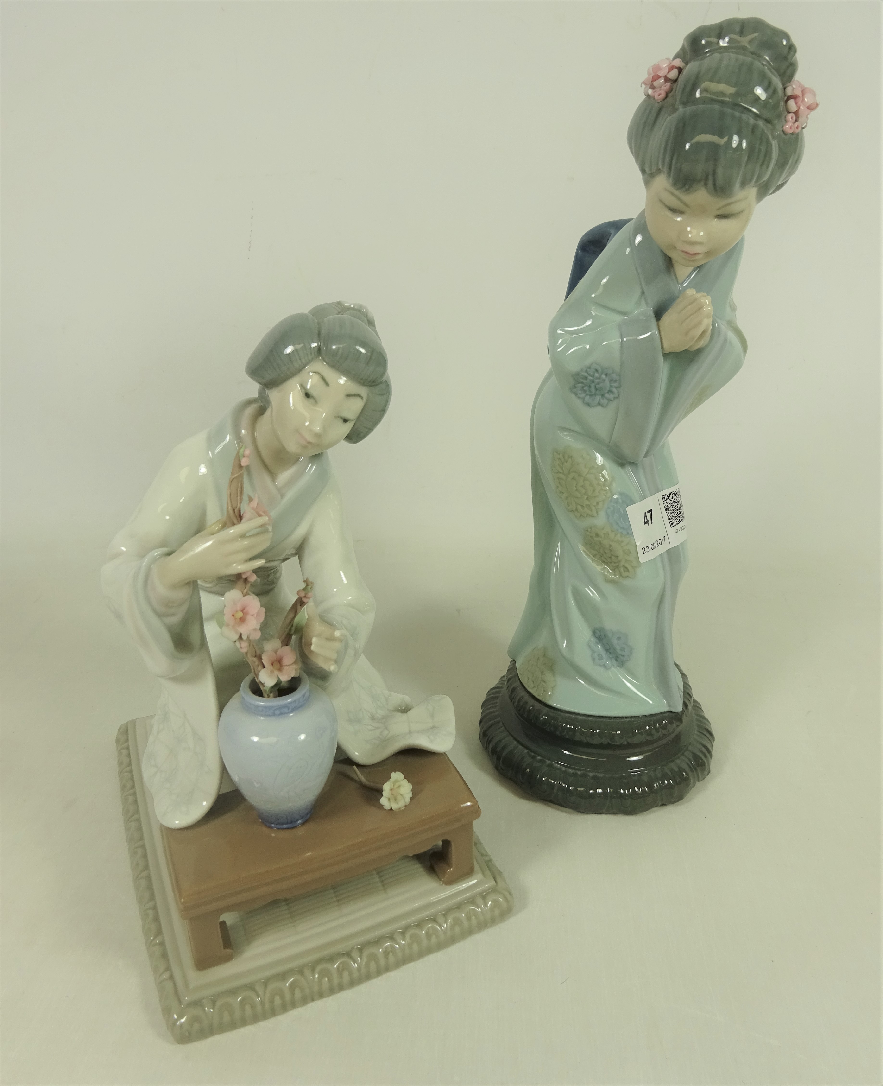 Two Lladro figures of geishas, one arranging flowers the other with hands in prayer H27.