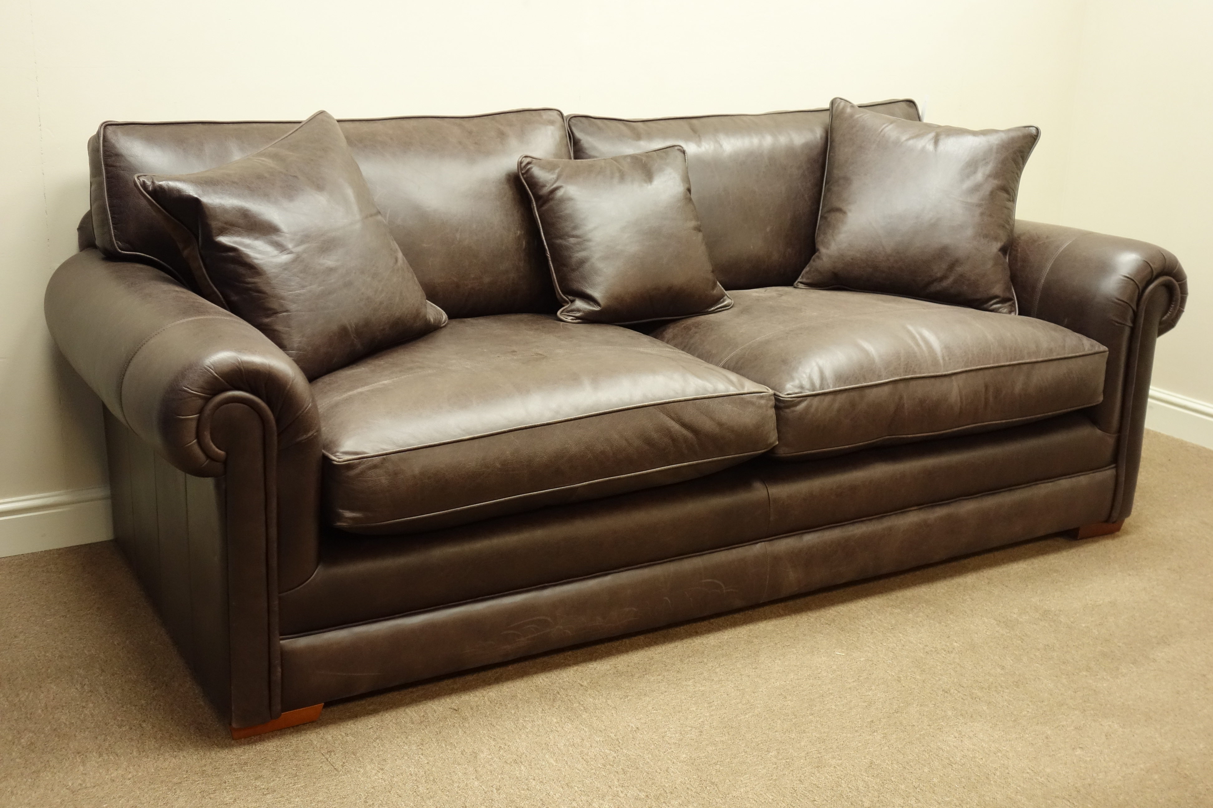 Large three seater sofa upholstered in brown 'Derwent' leather, with scatter cushions,