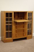 Mid 20th century light oak secritere bookcase, fall front with fitted interior above four drawer,