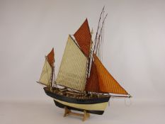 Wooden scale model of a twin masted fishing vessel, fully rigged, W57cm, H54cm, on stand.