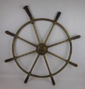 Brass eight-spoke ships wheel with wooden grips, one folding, the hub stamped Brown Bros & Co,