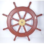 Eight spoked wooden ships wheel with central brass hub, red painted,