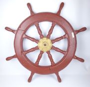 Eight spoked wooden ships wheel with central brass hub, red painted,