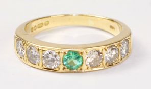 18ct gold ring set with six diamonds and a central emerald hallmarked Condition Report