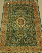 Pakistani 'Shahabbas' green ground rug, finely knotted, decorated with flowers and urns,