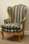 French style carved walnut wingback armchair upholstered in striped fabric with loose seat cushion