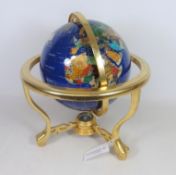 Polished mineral stone table globe on brass stand,