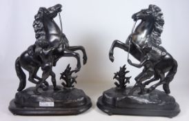 Pair of spelter Marly horseman models on oval plinths,