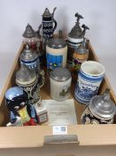 Collection of ten beer steins and a Carlton Ware figure ' Golly Newspaper Vendor '
