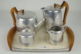 Four piece Piquot ware tea set on tray, with wooden handles,