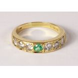 18ct gold ring set with six diamonds and a central emerald hallmarked