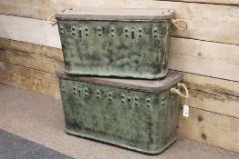 Two graduating industrial style metal and wood travelling trunks with rope handles,